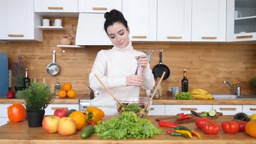 Woman Prepares Salad in Bright Kitchen