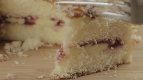 Eating slice of Victoria sponge cake with fork macro shot