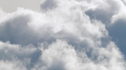 Fluffy Clouds Moving Across the Pale Blue Sky