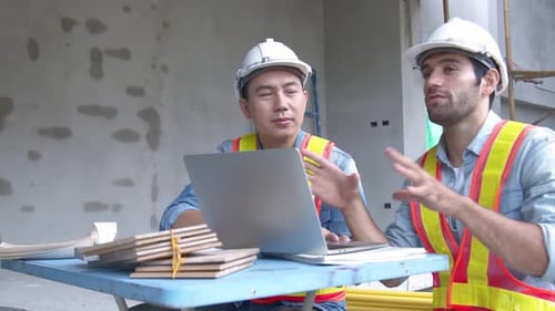 Young Asian engineers and caucasian engineer colleagues at site inspector and discuss together