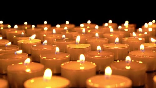 Many Tea Light Candles Flickering in the Dark