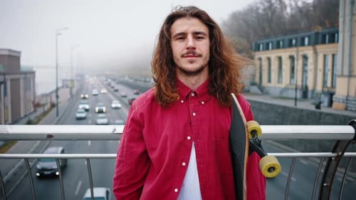 European Young Man Holding Skateboard and Looking at the Camera Portrait of Skater on the City