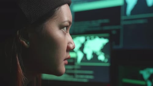 Close Up Asian Woman Hacker Using Computer Hacking, Code On Multiple Computer Screens