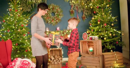 Smiling Woman Receives Christmas Gift from a Boy