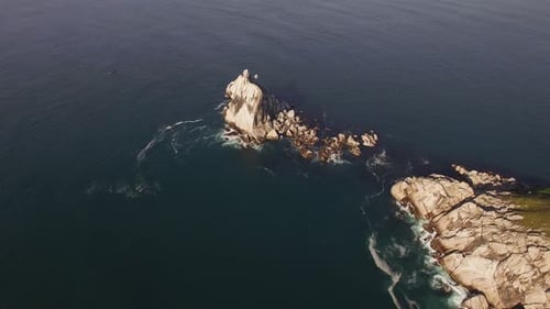 Aerial View of a Beautiful Small Rocky Island Surrounded By Clear Blue Sea