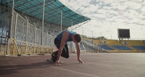 Sportler läuft aus der Startposition in der Hocke