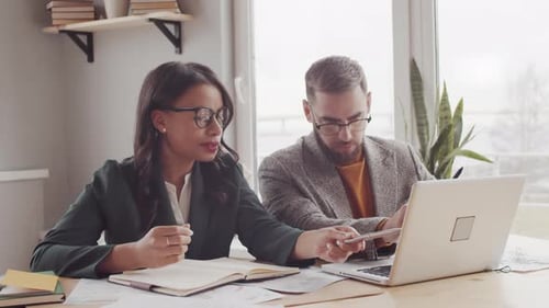 Business Colleagues Collaborating on Laptop in Bright Office