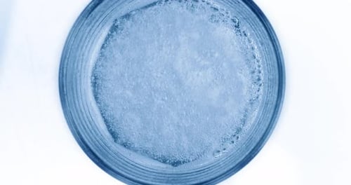 Bubbling Blue Liquid in Glass Top-Down Close Up