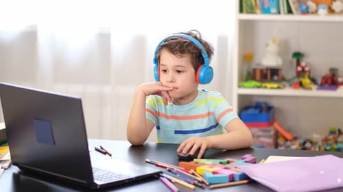 Boy Learning at Computer with Headphones at Home