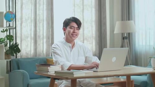 Man Using Laptop at Desk in Home Office