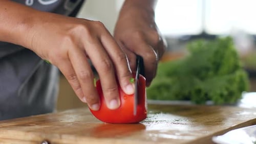 Tomato Slicing on Wooden Board with Kitchen Background