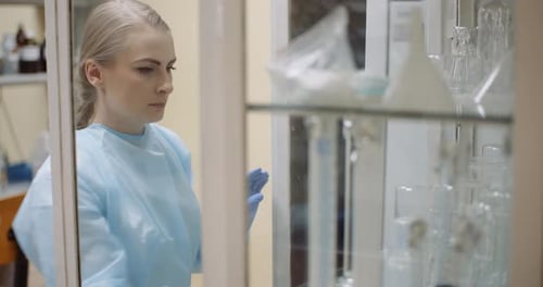 Scientist Looking for Flask at Laboratory