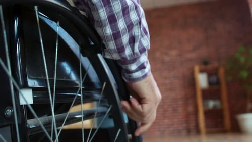 Adult Man Maneuvering Wheelchair Indoors