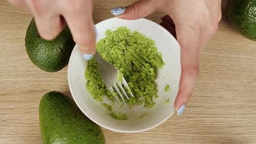 Mashing Fresh Avocado in a Bowl with Fork
