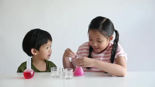 Children Doing Science Experiment Together at Home