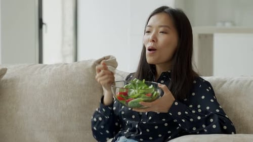 Woman Enjoying Healthy Salad at Home on Sofa