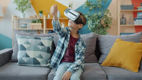 Boy Playing VR Game on Living Room Couch