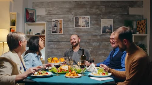 Adults Enjoying Dinner and Conversation Together Indoors