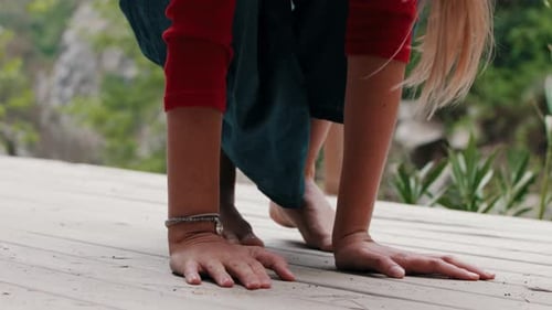 Woman Practicing Yoga Outdoors on Wooden Platform