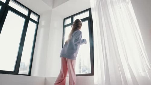 Energetic Young Woman Dancing in Bright Room