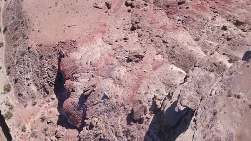 Aerial panning view from rocky desert terrain to muddy river