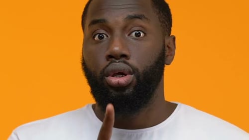 Afroamerikaner, der Stille macht, Geste, Nahaufnahme, Bitten, sei still, Verschwörung