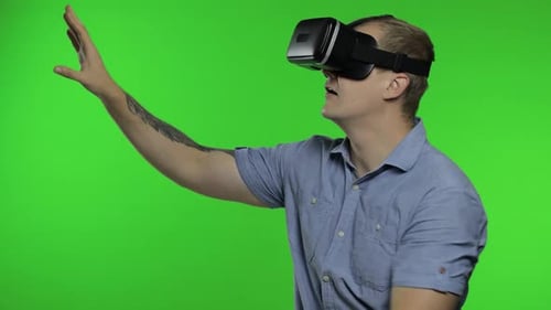 Young Adult Using Virtual Reality Headset on Green Screen