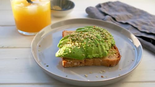 Eating Avocado Toast on White Wooden Surface