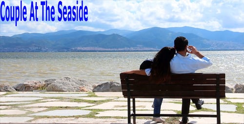 Couple Relaxing on Bench Overlooking Lake and Mountains