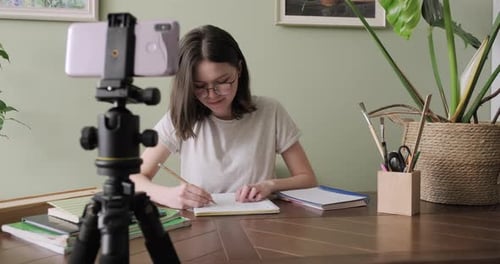 Adolescente étudiant en ligne à l'aide d'un smartphone, écoutant et parlant en vidéoconférence