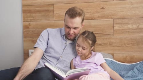 Father and Daughter Reading a Book Together