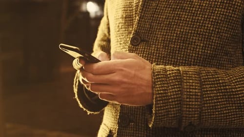 Close Up of a Man Hands Texting on Phone in a Winter Night in the Street