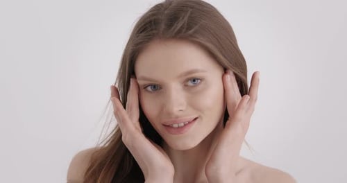 Woman Touching Face in Soft White Light