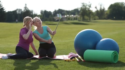 Smiling Fitness Senior Women Taking Selfie in Park