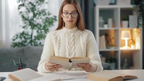 Woman Reading Book at Desk Indoors