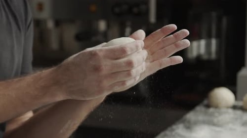 Baker Kneading Dough with Flour in a Kitchen