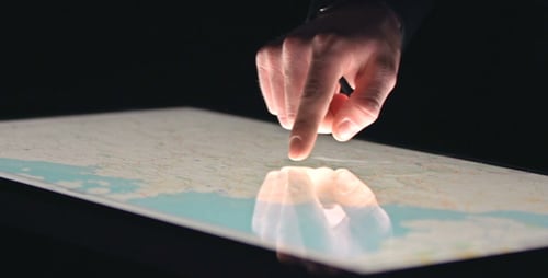 Hand Using Touchscreen Map on Dark Background
