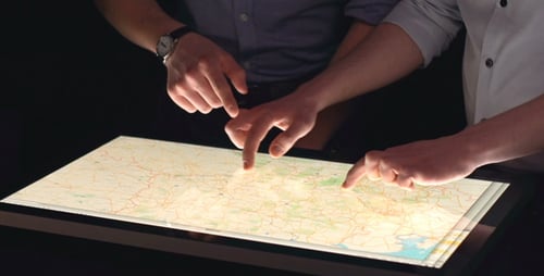 People Using Interactive Map on Touchscreen Table