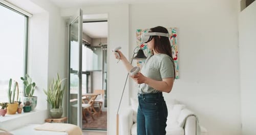 Woman Using Virtual Reality Headset and Controllers at Home