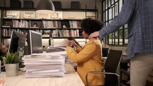 Un joven trabajador afroamericano ocupado está trabajando duro en una oficina comercial.