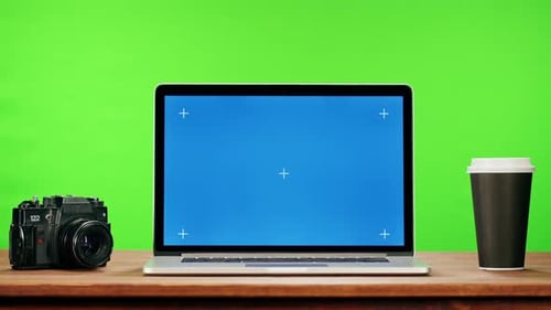 Laptop with Blue Chroma Key on Green Background Closeup Old Retro Photo Camera and Coffee Cup