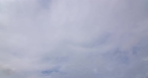 Fluffy White Clouds Drifting Across Blue Sky