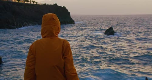 Tourist Enjoying Ocean View at Dusk or Twilight Storm and Wind Weather Waves Break on the Volcanic