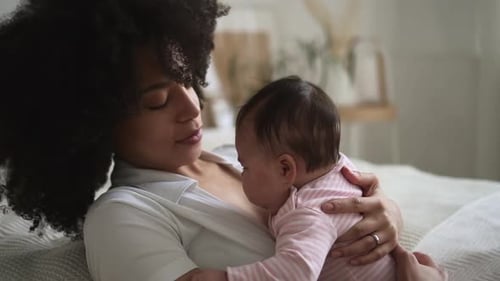 Mother Holding Her Baby in Bed