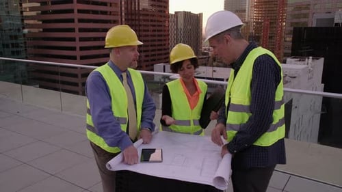 Drei Architekten schauen sich gemeinsam Pläne an
