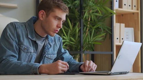Young Adult Using Graphic Tablet at Desk