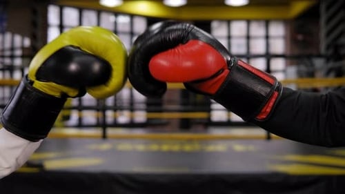 Primer plano de un hombre de negocios y una mujer con guantes de boxeo golpeándose