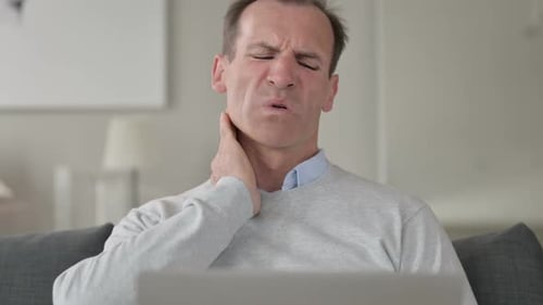 Man Experiencing Neck Pain Rubbing Sore Spot