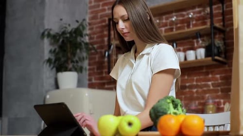 Woman Using Tablet with Fruit and Vegetables