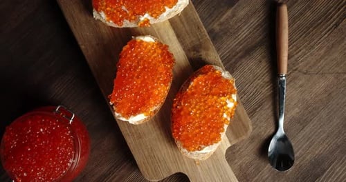 Red Caviar Sandwiches on a Wooden Table